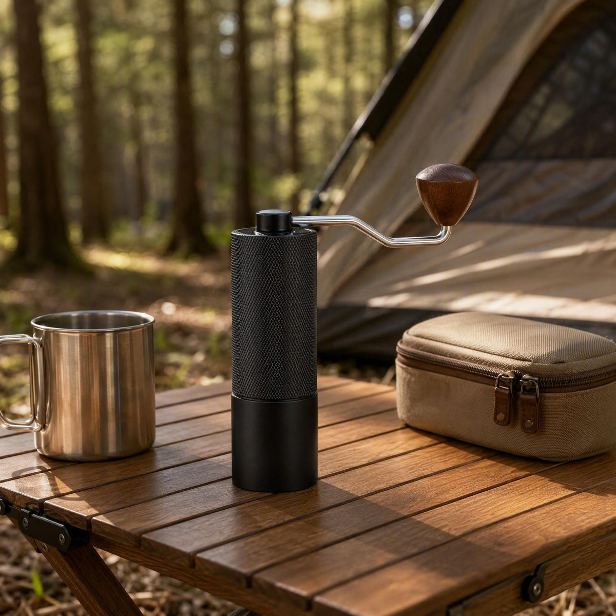 Slow Mill Manual Coffee Grinder Pro packed for camping on an outdoor table with a stainless steel cup and carry case